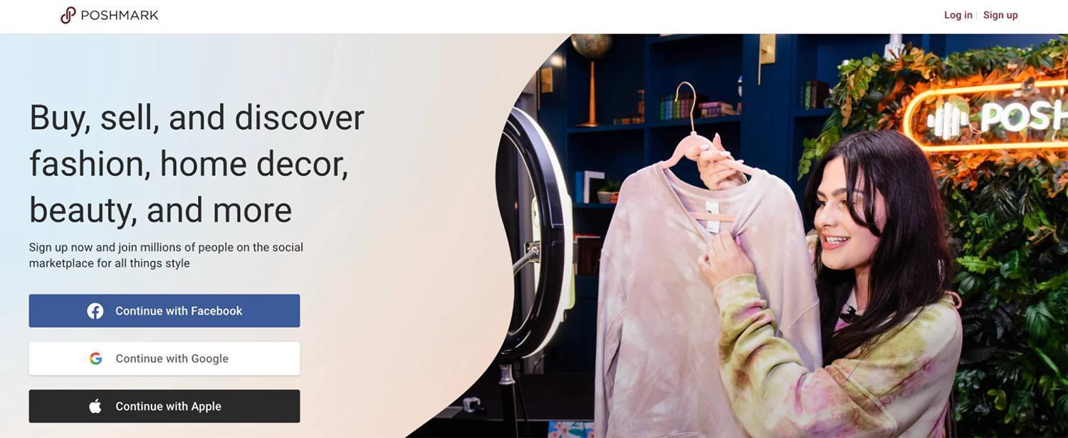 一个人在手机拍摄的直播中展示挂在衣架上的粉色扎染毛衣。